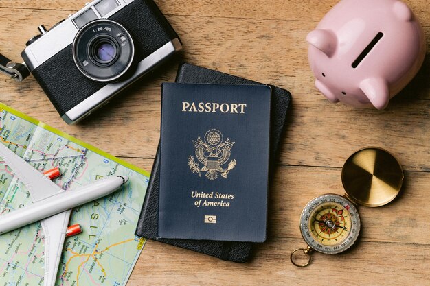 Pasaporte, brújula, mapa, cuaderno en una mesa de madera con una cámara