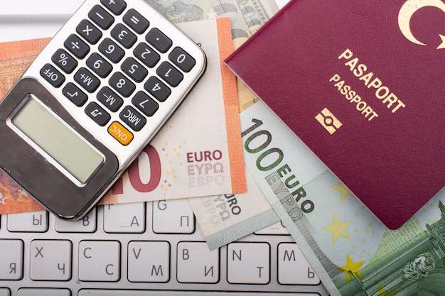 Pasaporte de un ciudadano de Turquía junto a billetes en euros y teclado de calculadora