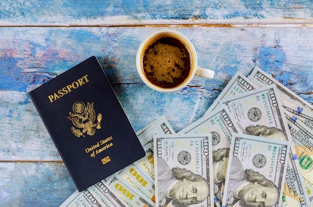 Pasaporte de Estados Unidos con billete de dólar y taza de café en la mesa de madera azul