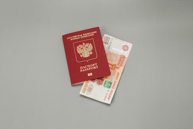 Pasaporte extranjero ruso y 5000 rublos rusos en efectivo sobre fondo gris Viajar al extranjero