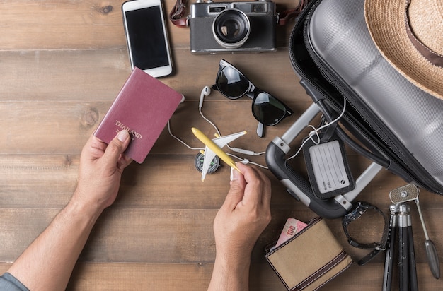 Pasaporte en mano hombre con maleta y accesorios