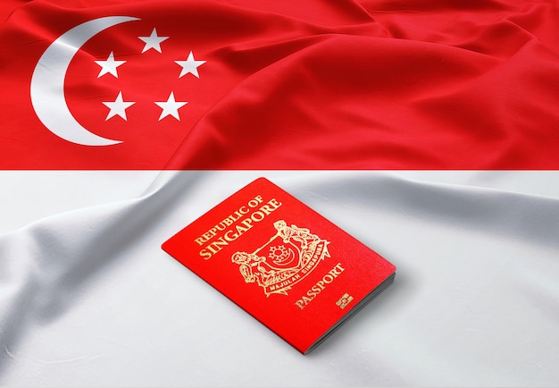 Pasaporte de Singapur en la parte superior de una bandera satinada de Singapur