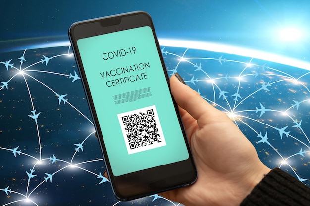 Pasaporte de vacunación con certificado verde digital en aplicación móvil para turismo de viaje Mano con teléfono inteligente y aviones voladoresElemento de imagen proporcionado por la NASA