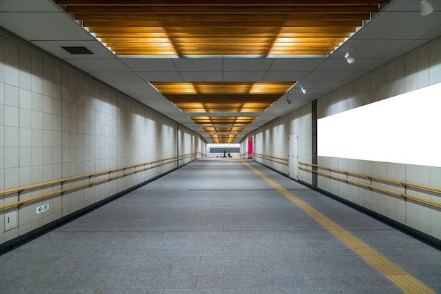 Pasarela con cartelera en blanco ubicada en la sala subterránea o metro