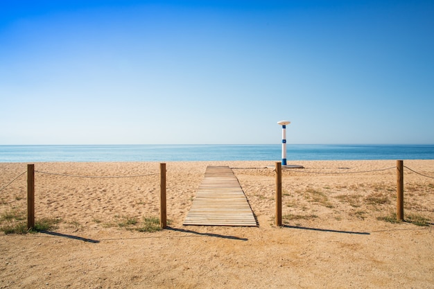 Pasarela de madera en la arena de la playa