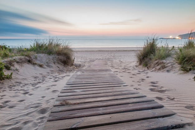 Pasarela de madera entrando a la playa al amanecer