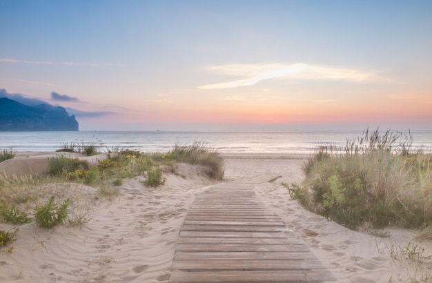 Pasarela de madera entrando a la playa al amanecer