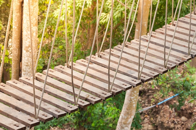 Pasarela del puente colgante a la cruz aventurera al bosque del otro lado