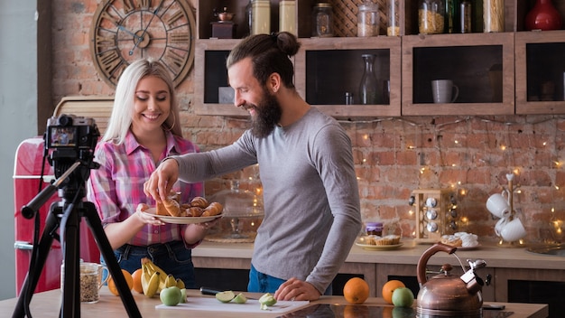 Foto pasatiempo de cocina y estilo de vida. vlog familiar. transmisión de video de una pareja joven en la cocina. delicia de frutas y pasteles.