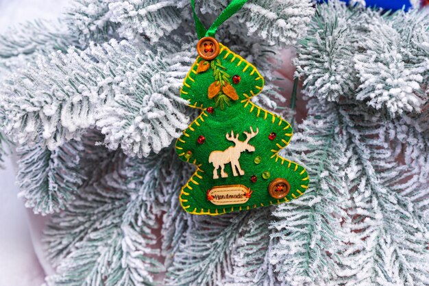 Pasatiempo creativo de bricolaje Hacer adornos navideños artesanales hechos a mano y bolas con abeto de fieltro árbol de navidad con bolas coloridas y cajas de regalo sobre una pared de ladrillo blanco con bolas azules y blancas