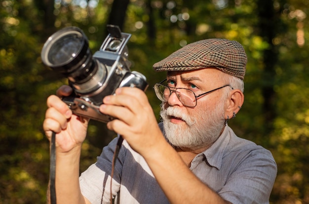 Pasatiempo de pensiones. Fotógrafo experimentado. Cámara vintage. Anciano dispara a la naturaleza. Fotógrafo profesional. Haz un marco perfecto. Foto de la naturaleza del paisaje. Viejo fotógrafo filmando. Ajustes manuales.