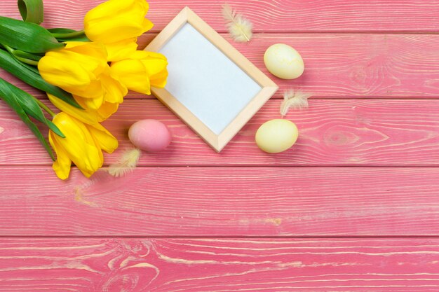 Páscoa . Moldura de madeira com ovos de Páscoa e tulipas em colorido