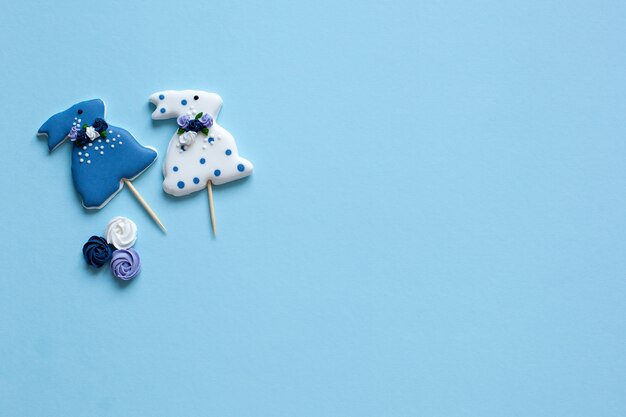 Páscoa - vitrificada coelho em forma de biscoitos na parede branca. A parede feliz de easter com pastel coloriu cookies de easter - coelhos e flores. Flores da primavera e coelhos de gengibre de Páscoa na mesa.