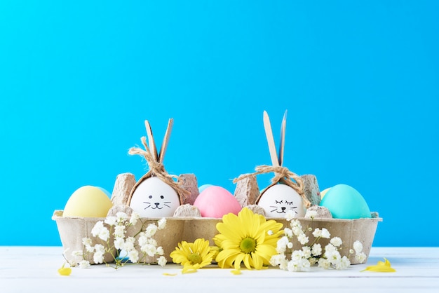 Pascua coloreó los huevos en la bandeja del papel con decorationd en un fondo azul