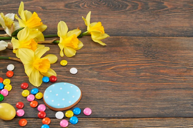 Foto pascua glaseó galletas, bolas de chocolate y narcisos.