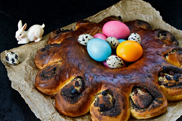 Pascua para hornear. Corona de pascua Una guirnalda de masa. Huevos de Pascua. Hornear y los huevos sobre un fondo oscuro.