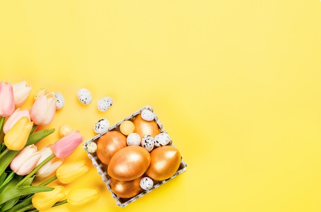 Pascua huevos de pascua decorativos de oro ramitas de sauce y tulipanes Concepto de vacaciones de primavera