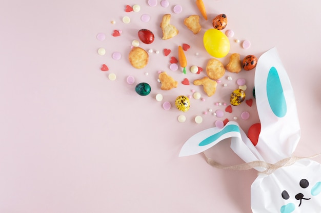 Pascua pintó huevos y dulces sobre fondo rosa