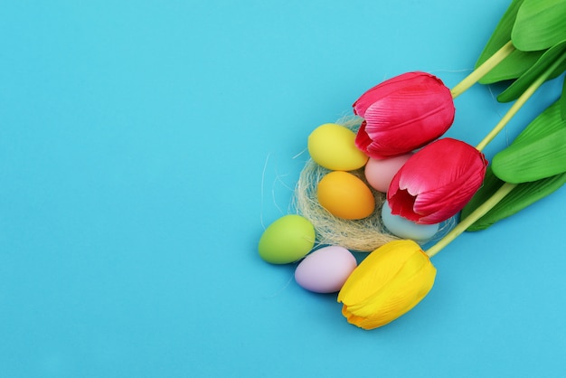 Pascua pintó huevos con un nido y flores de tulipanes