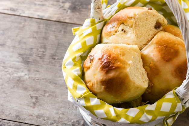 Pascua tradicional hot cross bollos en una cesta en la mesa de madera, espacio de copia