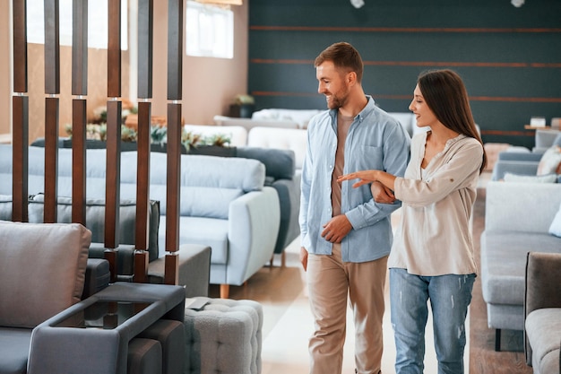 Paseando Pareja eligiendo el sofá y la cama en la tienda