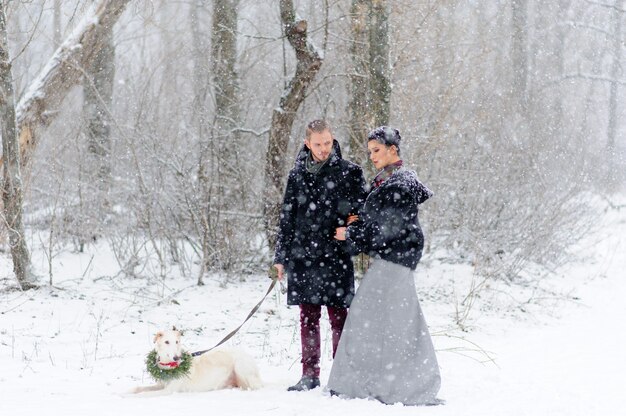 Paseo de invierno en una tormenta de nieve con un perro