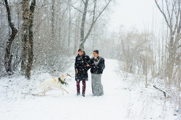 Paseo de invierno en una tormenta de nieve con un perro