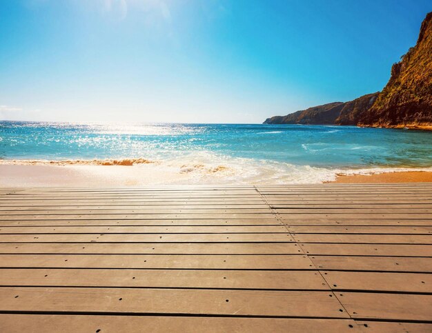 Un paseo marítimo de madera con un cielo azul y el mar de fondo