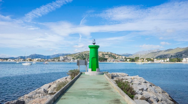 paseo marítimo con mar en calma y pequeño faro