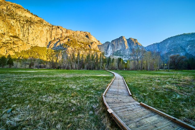 Paseo marítimo que serpentea a través del campo de hierba que conduce a las cataratas de Yosemite superior