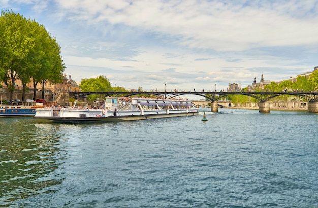 Paseos en barco turístico debajo del Pont des Arts en el río Sena en París, Francia