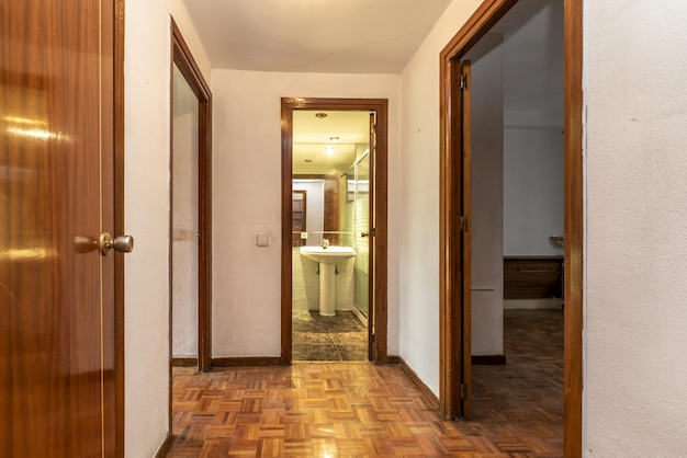 Pasillo distribuidor de una casa urbana con suelos de parquet de madera de jatoba y armarios empotrados con puertas de madera