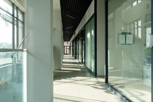 Un pasillo en un edificio de oficinas de tipo urbano Interior moderno del vestíbulo de un edificio de oficinas con paredes de puertas de vidrio y ventanas grandes y espaciosas Un pasillo largo iluminado en un moderno centro de negocios