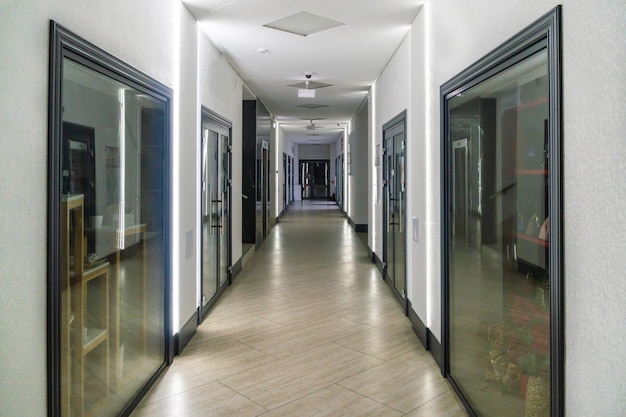 Un pasillo en un edificio de oficinas de tipo urbano Interior moderno del vestíbulo de un edificio de oficinas con puertas de vidrio y paredes blancas limpias Un pasillo largo iluminado en un moderno centro de negocios