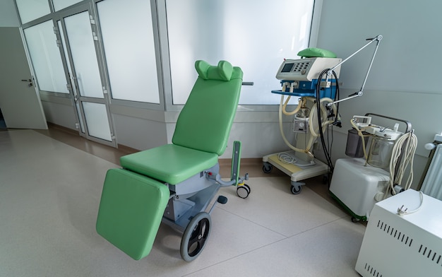 En el pasillo del hospital hay una silla de ruedas para transportar pacientes. De cerca.