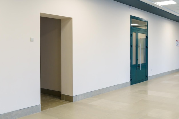 Un pasillo vacío en un edificio de oficinas Puertas cerradas a la oficina y al vestíbulo Un amplio salón luminoso en el centro de negocios Entrada y salida de la habitación
