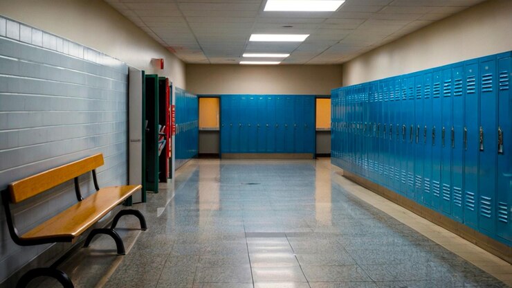 Un pasillo vacío de la escuela con una larga fila de casilleros de metal azul
