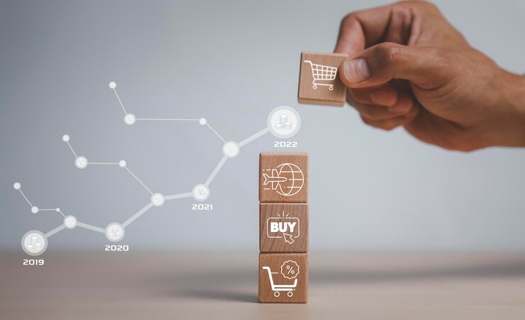 Foto paso de bloque de madera de cubos de mano en la mesa con carrito de compras de icono en el fondo blanco, reducción de precio del producto, concepto de compra en línea, gestión de proyectos, desarrollo de estrategia de empresa.