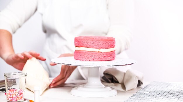 Paso a paso. Apilando capas juntas de pastel de cumpleaños rosa.