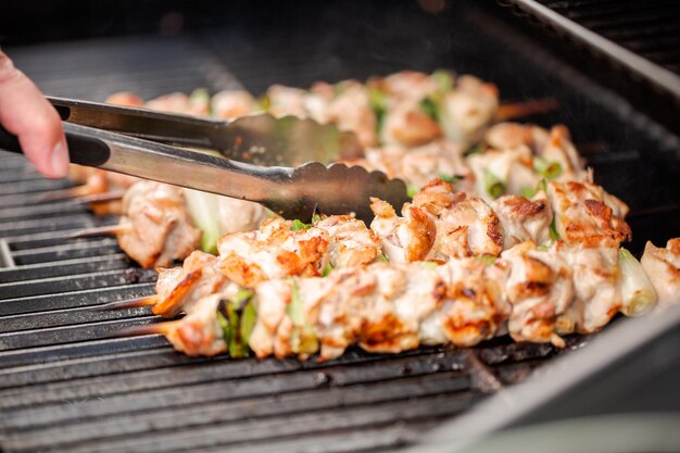 Paso a paso. Asar pollo yakitori en brochetas de bambú en una parrilla de gas al aire libre.