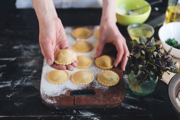 Paso a paso el chef prepara ravioles con queso ricotta, yemas de huevos de codorniz y espinacas con especias. El chef se prepara para cocinar ravioles