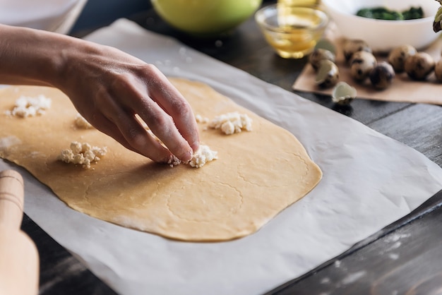 Paso a paso el chef prepara ravioles con queso ricotta, yemas de huevos de codorniz y espinacas con especias. El chef prepara el relleno de la masa.