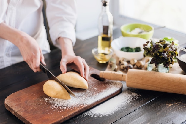 Paso a paso el chef prepara ravioles con queso ricotta, yemas de huevos de codorniz y espinacas con especias. El chef trabaja con la masa