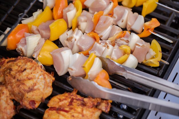 Paso a paso. Cocinar brochetas de pollo con pimientos y cebollas amarillas en una parrilla de gas al aire libre.