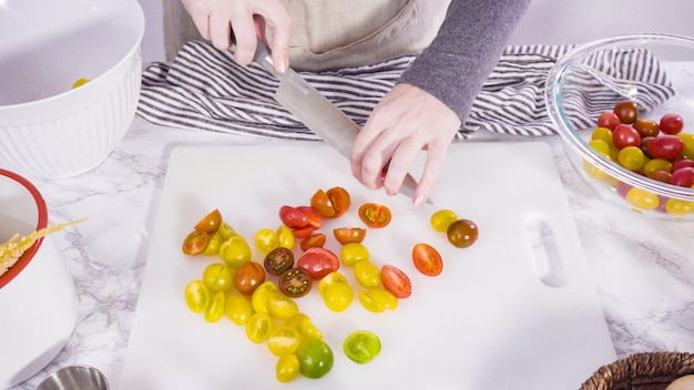 Paso a paso. Cortar verduras en una tabla de cortar blanca para hacer una receta de pasta en una sola olla.