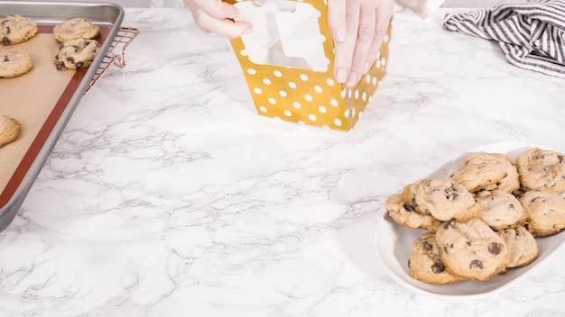 Paso a paso. Empaquetado de galletas con trocitos de chocolate caseras en una pequeña caja de regalo.