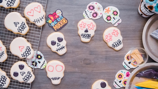 Foto paso a paso. endecha plana. decoración de galletas de calaveras de azúcar con glaseado real de diferentes colores.