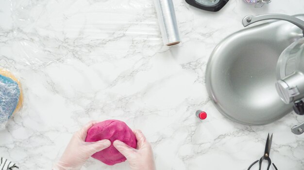 Paso a paso. Endecha plana. Mezcle colorante alimentario en la masa para galletas para hornear galletas de azúcar en forma de molinete rojas, blancas y azules.