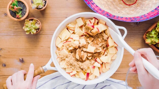 Paso a paso. Freír manzanas rojas con azúcar moreno para rellenar para hacer empanadas.