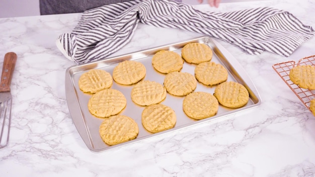 Paso a paso. Galletas de mantequilla de maní recién horneadas en una bandeja para hornear.